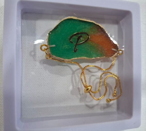 Rakhi cum Bracelet – Green-Orange “P” Initial Resin Charm